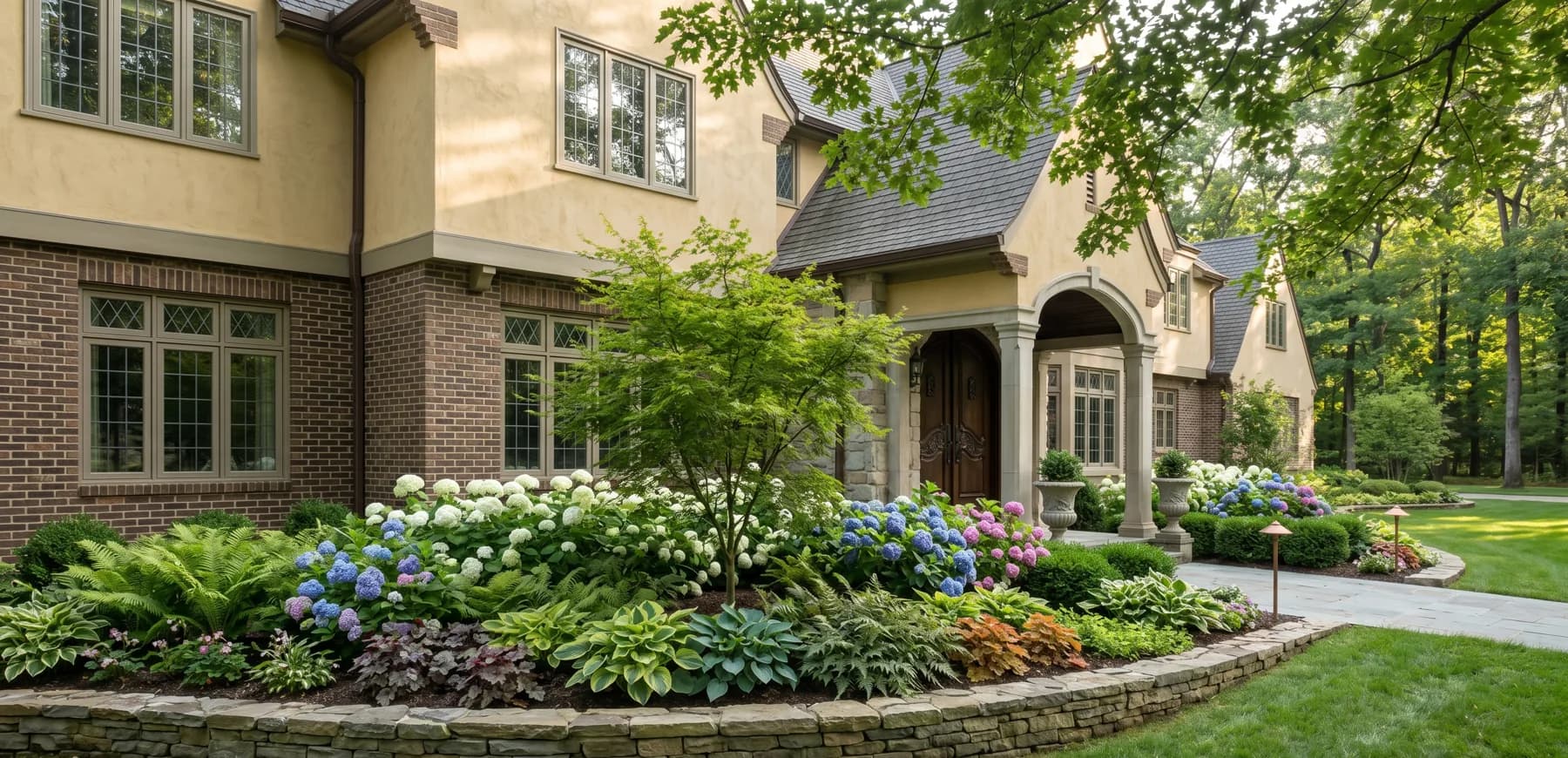 Shade foundation bed with layered plantings after a completed design install