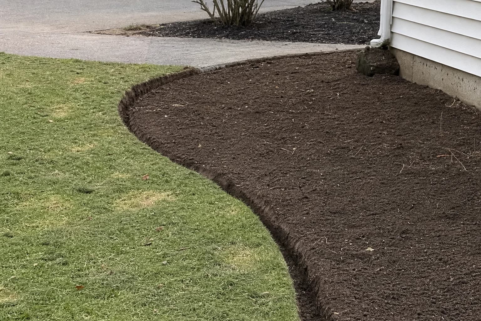 Perfectly prepped landscape bed with clean trench edge and weed-free soil