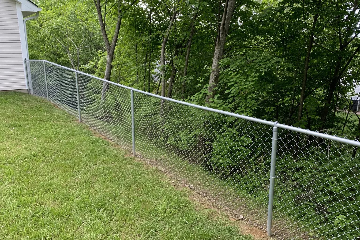 Chain link fence following a sloped backyard grade